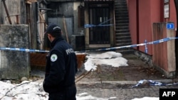 A police officer walks past a crime scene from a deadly shooting incident in Cetinje, which left a dozen people dead in the Montenegrin city late on January 1.