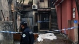 A police officer walks by the crime scene in Cetinje, Montenegro, on January 2, 2025, after a gunman went on a rampage after opening fire at a village restaurant, killing 12 people including two children.