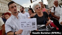  Протестиращ с афиш, който имитира самолетен билет до Сицилия. Това е отпратка към изявление на депутата от Има Такъв Народ Тошко Йорданов, който сподели, че в случай че на младите лекари не им харесва в България, могат да заминат за чужбина 