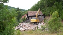 Një ekskavator duke shembur një shtëpi buzë Liqenit të Ujmanit më 21 korrik.