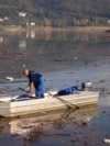 Ibro Mešić prikuplja plastični otpad na Jablaničkom jezeru sa svog čamca.