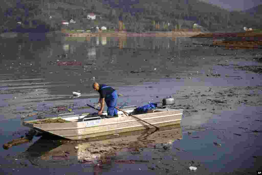 Ibro Mešić prikuplja plastični otpad na Jablaničkom jezeru sa svog čamca.