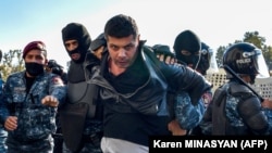 Ermeni polisiýasy 11-nji noýabrda Ýerewanda geçirilen hökümete garşy ýörişde bir protestçini tussag edýär.