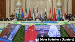 Participants listen as Chinese President Xi Jinping delivers a speech via video link during the Shanghai Cooperation Organization summit in Dushanbe on September 17.
