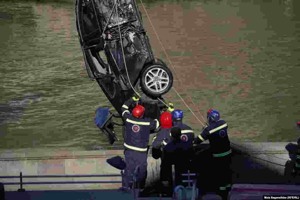 4 მარტი, თბილისი - რამდენიმესაათიანი მცდელობის შემდეგ მაშველებს მტკვრიდან წყალში გადავარდნილი მანქანა და მისი გარდაცვლილი მძღოლი ამოჰყავთ.უცნაური დამთხვევის თუ სხვა გაურკვეველი მიზეზის გამო, მარტში მეტეხის ხიდიდან ერთ კვირაში ორი ავტომობილი გადავარდა.ფოტო: მზია საგანელიძე