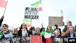 Демонстранти држат транспаренти и портрети додека демонстрираат пред канцеларијата на Обединетите нации пред индиректните нуклеарни разговори меѓу САД и Иран во Женева, 17 февруари 2026 година.