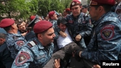 Armenian police officers detain a protester at an anti-government demonstration in Yerevan on May 5,
