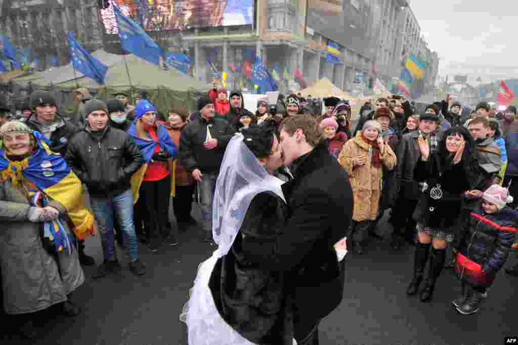 A newly wed couple kiss on Independence Square as pro-European protesters occupy Kyiv&#39;s central square, December 21, 2013.