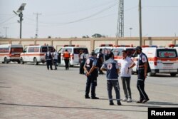 Zdravstveni radnici čekaju da odvedu ranjene Palestince na lečenje u Egipat.