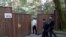 Russian police officers enter a guest-house property used by U.S. diplomats for recreation in Moscow's leafy Serebryany Bor district on July 31.