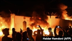 Demonstrators gather as flames start consuming Iran's consulate in the southern Iraqi city of Najaf on November 27. 