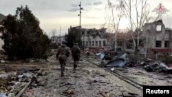 Russian forces walk through the recaptured city of Sudzha in the Kursk region in a photo released by the Russian Defense Ministry.