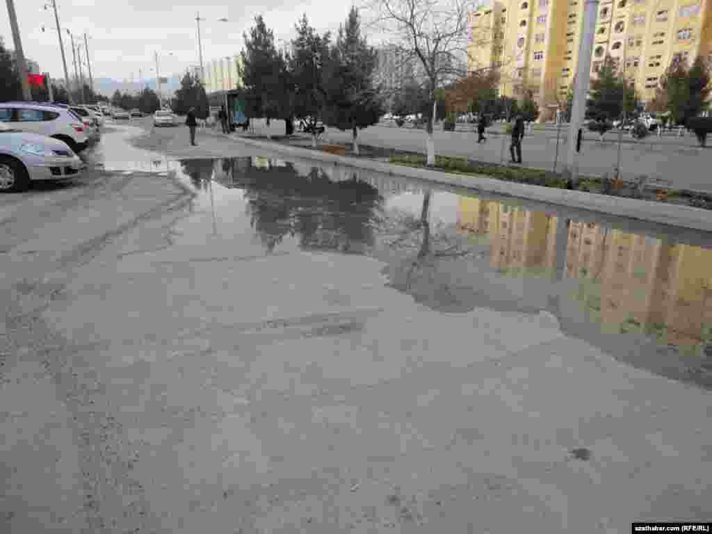 Aşgabadyň Parahat-4 mikroraýonynda ýarylan suw turbasyndan köçä akyp duran suw