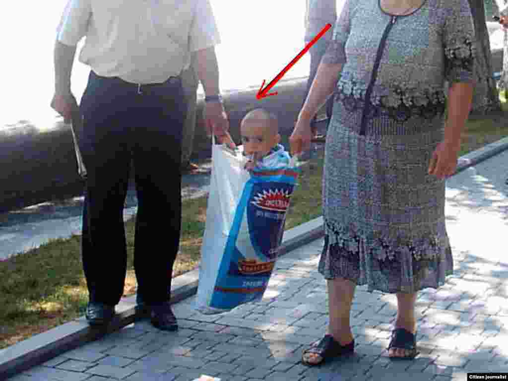 Azerbaijan – child in carrier bag (Mobile reporter)