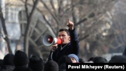 Протестующий говорит в мегафон во время митинга сторонников оппозиции в день парламентских выборов в Алматы, Казахстан, 10 января 2021 года. 