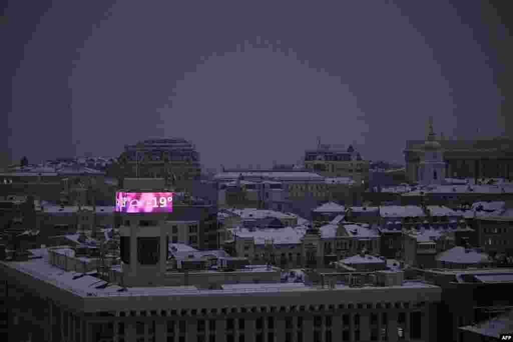 Un ecran mare pe o clădire care afișează o temperatură de -19 grade Celsius în Kiev, pe 15 ianuarie.