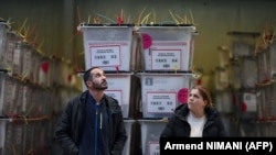 Службеници на Централната изборна комисија до гласачките кутии во Центарот за пребројување гласови во Приштина, 24 јануари 2026 година.