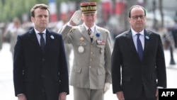 Current French President Francois Hollande (second-right) and President-elect Emmanuel Macron (left) take part in a ceremony to mark the end of World War II, in Paris on May 8. 