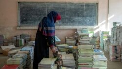 Кабул мектебіндегі ауған мұғалімі кітаптарды топтастырып жатыр. 2022 жылғы желтоқсан.