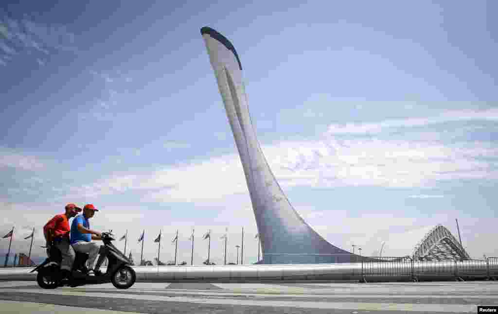 Men ride a scooter through the Olympic park in Sochi, Russia. (Reuters/Maxim Shemetov)