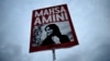 Mahsa Amini's death after a dress-code detention sparked a movement in Iran and abroad, including in Germany, where a protester held up this image of the 22-year-old student in the days after Amini's death.