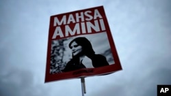 Mahsa Amini's death after a dress-code detention sparked a movement in Iran and abroad, including in Germany, where a protester held up this image of the 22-year-old student in the days after Amini's death.