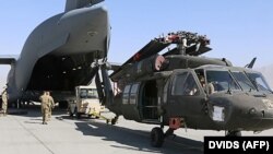 Aerial porters work with maintainers to load a UH-60L Blackhawk helicopter into a C-17 Globemaster III at Bagram Airfield on June 16.