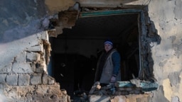 A resident stands inside an apartment damaged by recent shelling in Donetsk, Russian-controlled Ukraine, on November 28.