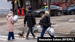 Trei persoane cu colete comandate de pe platforme internaționale, la scurt timp după ieșirea dintr-un oficiu poștal din Chișinău, 31 decembrie 2025.