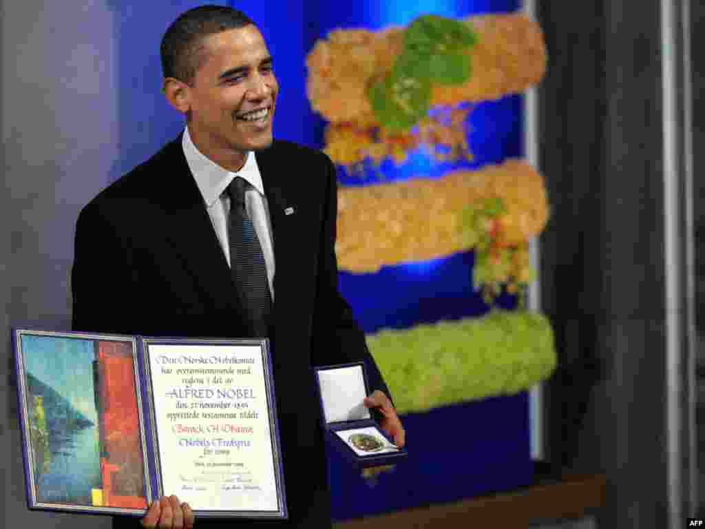 U.S. President Barack Obama poses with his Nobel Peace Prize in Oslo. - As Obama accepted the Nobel Peace Prize on December 10, he faced the difficult task of reconciling the peace award with his decision to send 30,000 troops to escalate the war in Afghanistan. Photo by Jewel Samad for AFP