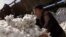 UZBEKISTAN -- file -- Uzbek worker pushes raw cotton at the Chinaz ginnery, some 70 km (44 miles) southwest of the capital Tashkent, September 30, 2003. 