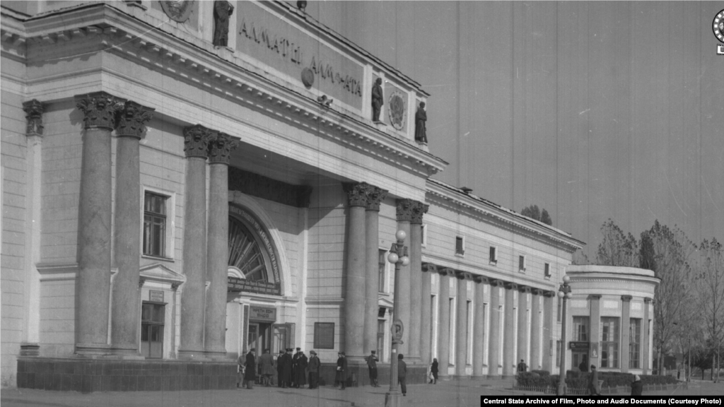 Здание железнодорожного вокзала в городе Алма-Ате. 1950 год (слева).&nbsp;В&nbsp; Верном &mdash; так назывался город до 1921 года &mdash; в этом районе располагалось кладбище. К моменту строительства вокзала погост был снесен селевым потоком. Здание строилось в 1936&ndash;1939 годах архитекторами Галкиным и Кудрявцевым. Пережило реконструкцию в 1977 году и капитальный ремонт в 2012-м. Выходящая к вокзалу улица четыре раза меняла свое наименование: названная Старокладбищенской во времена Верного, в 1933 году она превратилась в проспект Сталина, в 1961 году стала Коммунистическим проспектом, а сейчас называется Абылай-хана. 
