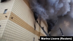 Firefighters work to extinguish the fire that engulfed the Zimnyaya Vishnya shopping mall in Kemerovo, killing 60 people, in March 2018.