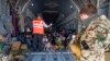 Un membru al staff-ului aeronavei informează evacuații din Afganistan, aflați la bordul unui avion de transport A400 al Forțelor Aeriene Germane, la sosirea pe aeroportul din Tașkent/Uzbekistan - 19 august 2021
