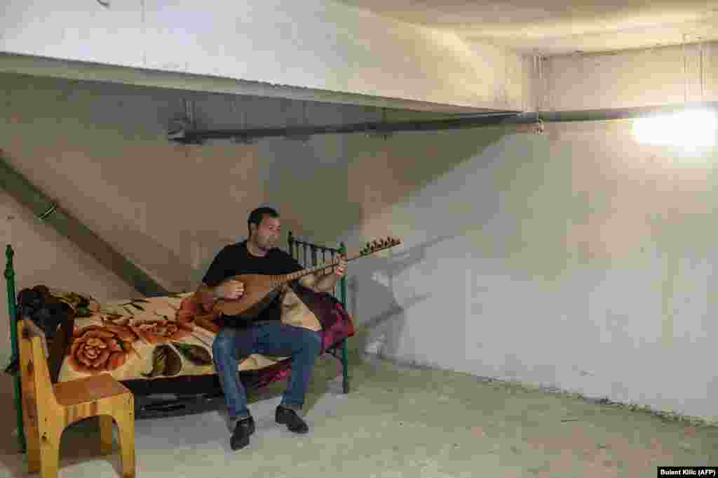 Qowkar Movsumov, 32, plays on a string instrument while sheltering in Tartar on October 19.
