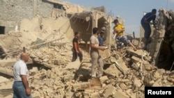 People walk through the rubble of a Shi'ite mosque after it was destroyed in a bomb attack by militants of the Islamic State, formerly known as the Islamic State in Iraq and the Levant (ISIL), in the Iraqi city of Mosul on July 23. 