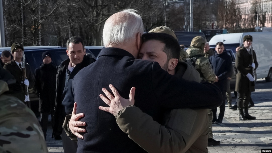 Președintele SUA, Joe Biden, și președintele Ucrainei, Volodimir Zelenski, se îmbrățișează după vizita la Zidul Amintirilor, unde au adus un omagiu soldaților ucraineni uciși în război. Kiev, Ucraina, 20 februarie 2023.