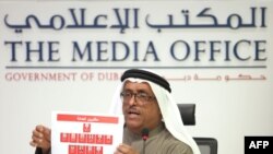 Dubai police chief Dhafi Khalfan holds up identity pictures of 11 suspects in the Hamas commander's killing during a press conference in Dubai on February 15.