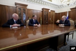 Ruski predsjednik Vladimir Putin tokom sastanka s vršiteljem dužnosti premijera i ministrom industrije i trgovine Denisom Manturovom (u sredini) i izvršnim direktorom državne korporacije Rostec Sergejem Čemezovom u Kremlju, maj 2024.