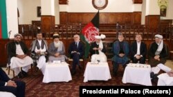 Afghan President Ashraf Ghani flanked by former President Hamid Karzai and other prominent members of Afghanistan’s often-divided political elite.