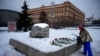 A woman lays flowers to pay tribute to Aleksei Navalny at the monument to political prisoners with the Federal Security Service building in the background in Moscow on February 21.