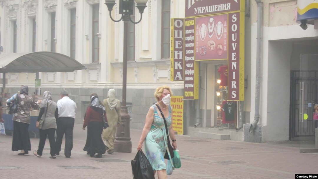 A woman in Moscow wears a protective mask in the thick smog.