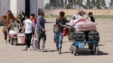 Əfqan qaçqınlar İrandan deportasiya edildikdən sonra əşyalarını daşıyırlar.