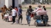 Afghan refugees carry their belongings after being deported from Iran at the Islam Qala border crossing between Afghanistan and Iran. (file photo)