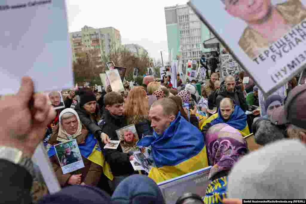 Звільнені чоловіки проходять коридором, який утворили рідні тих, хто все ще залишається в російському полоні або вважається зниклим безвісти, 11 квітня 2026 року
