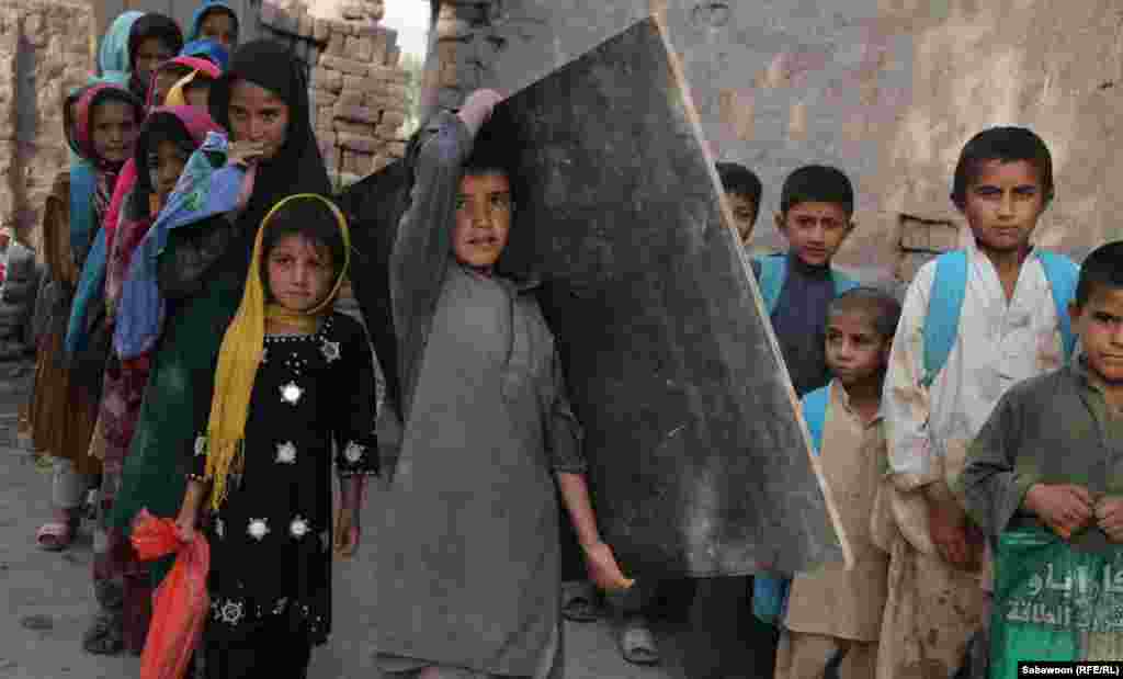 افغانستان: د جلال اباد ښار په څنډو کې افغان ماشومان د خپل ښوونځي ټولګي ته درومي.