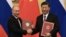 Russian President Vladimir Putin (left) and Chinese President Xi Jinping shake hands during a signing ceremony inside the Great Hall of the People in Beijing on June 8.