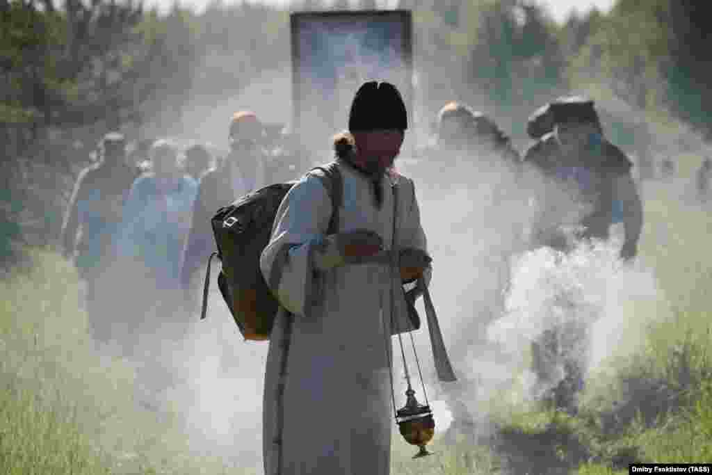 An Orthodox priest leads pilgrims in the procession.