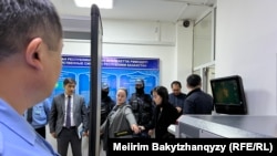 "Атажұрт" белсенділерінің ісі бойынша жауапқа тартылып жатқан Тұрсынбек Қабидің әйелі Оралхан Әбенді сот ғимаратына кірберісте қауіпсіздік қызметкерілері тексеріп жатыр. Талдықорған, 9 сәуір, 2026 жыл.