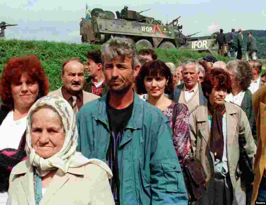 Bošnjačke izbjeglice stoje u redu za glasanje, dok ih u pozadini osiguravaju međunarodne vojne trupe, u Doboju, sjeverna Bosna, 14. 9. 1996.
